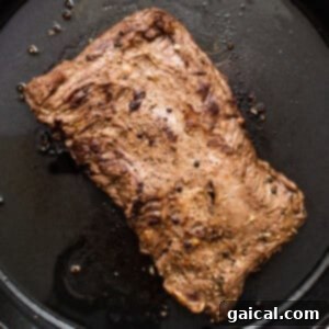 Mastering Skirt Steak Cooking 13 A piece of steak being seared in a hot cast iron pan.