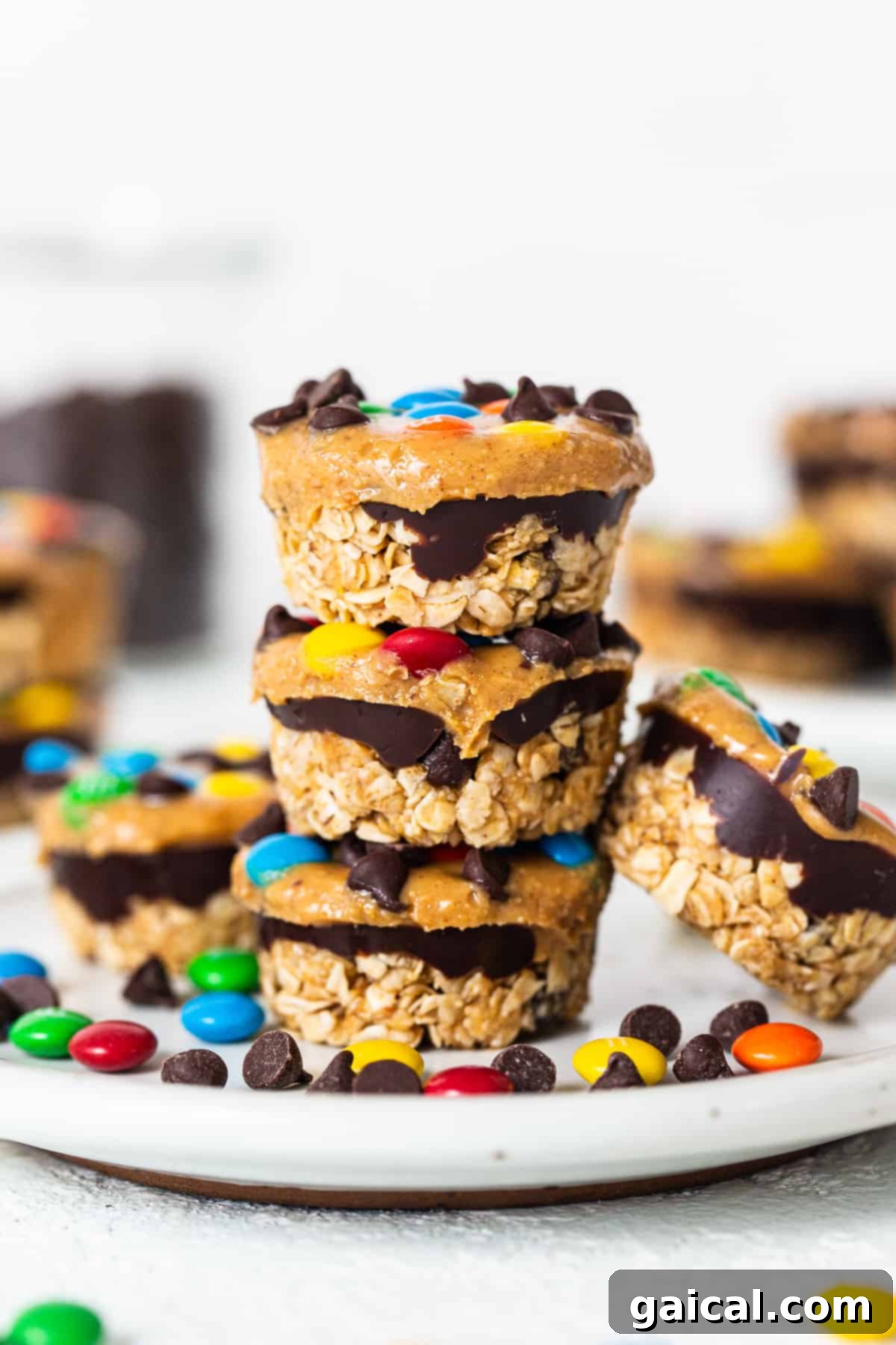 Monster cookie oat cups stacked invitingly on top of each other, showcasing their layers of oats, chocolate, and colorful toppings.