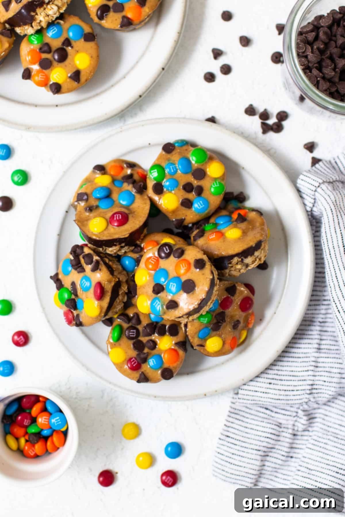 A generous pile of monster cookie oat cups artfully arranged on a white plate, ready for serving.