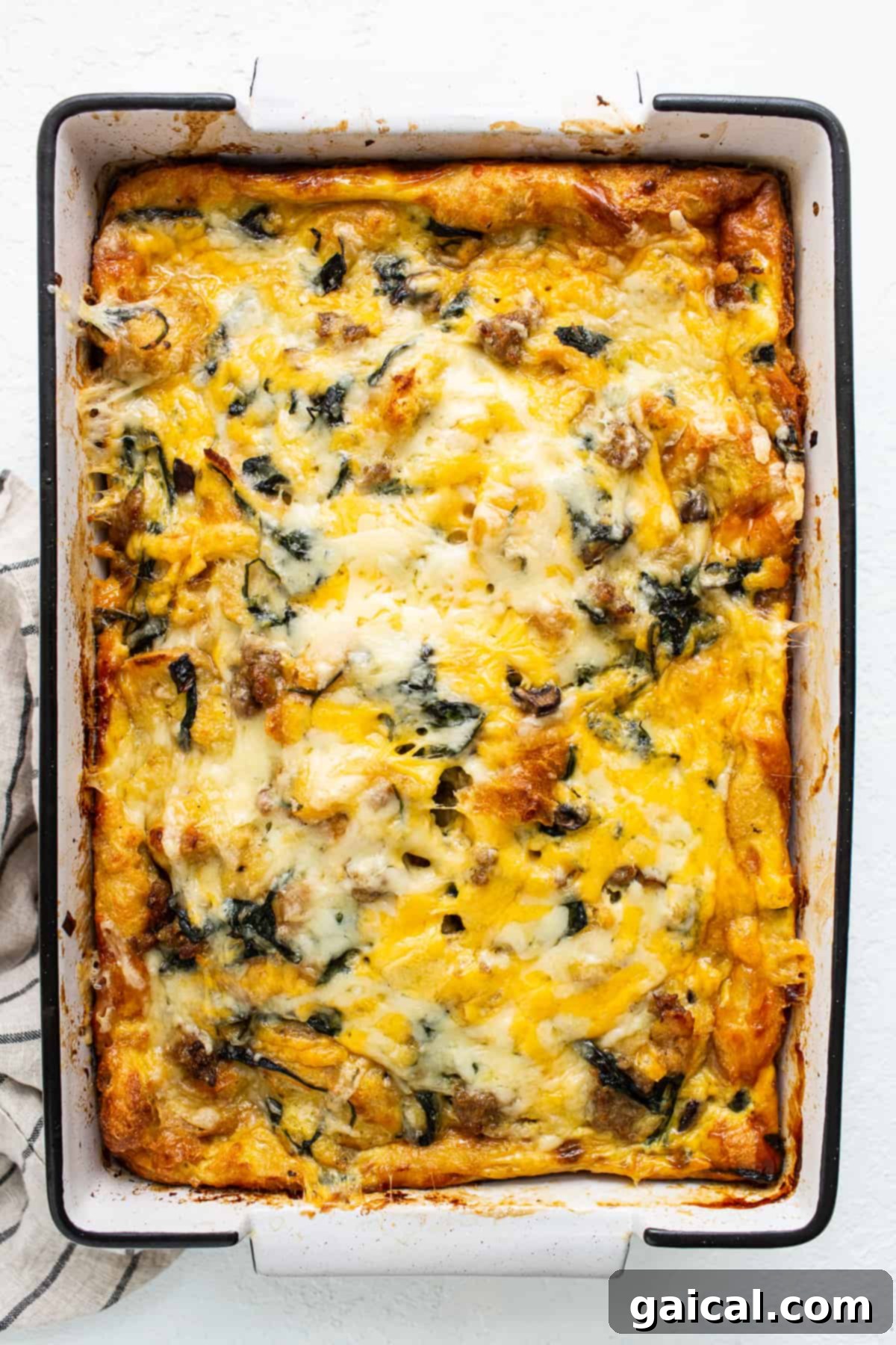 Baked Golden Brown Breakfast Strata Breakfast strata baked to a golden brown perfection in a casserole dish, topped with melted cheese.