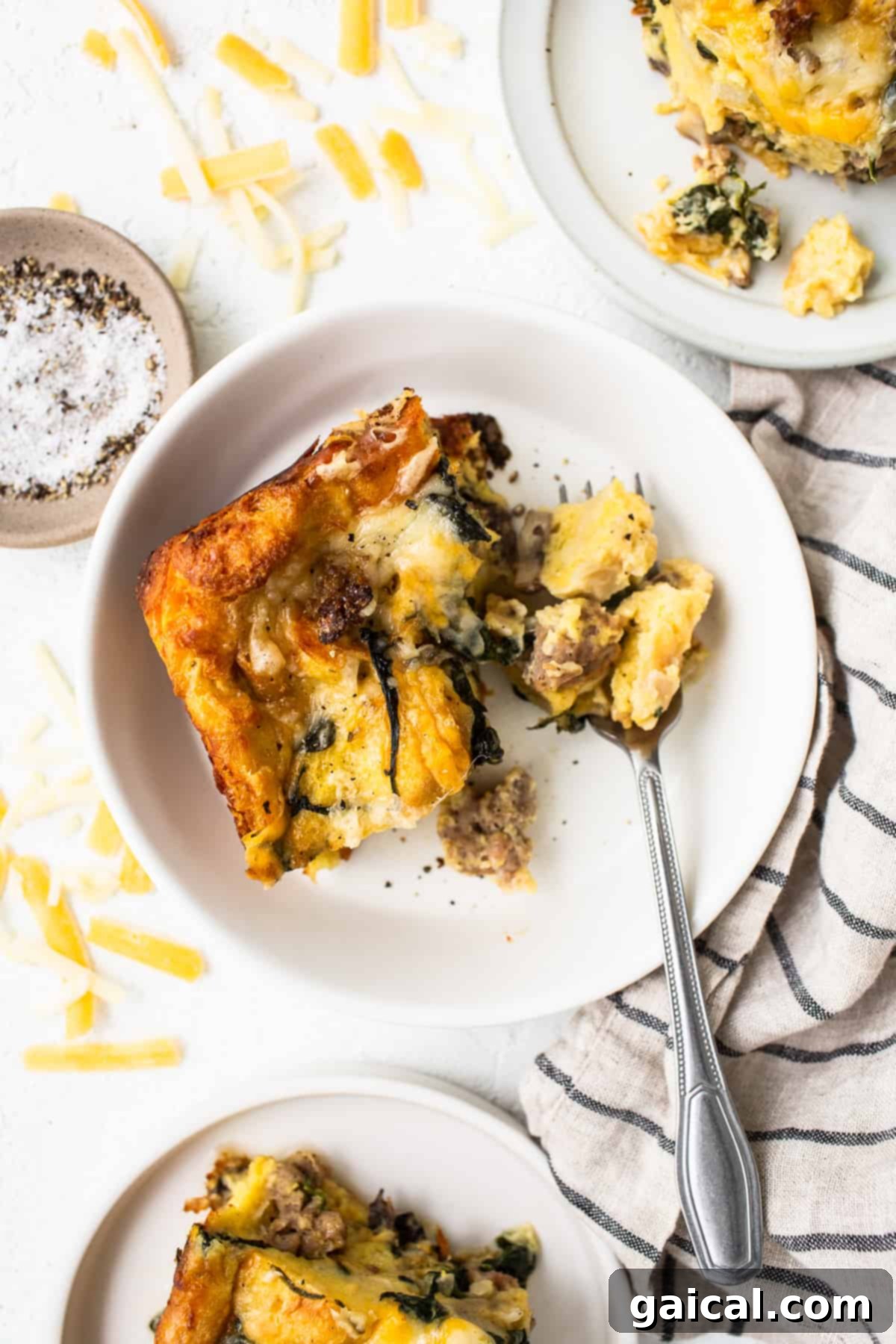 Perfectly Sliced Breakfast Strata A perfectly cooked slice of breakfast strata on a clean white plate, ready to be served.