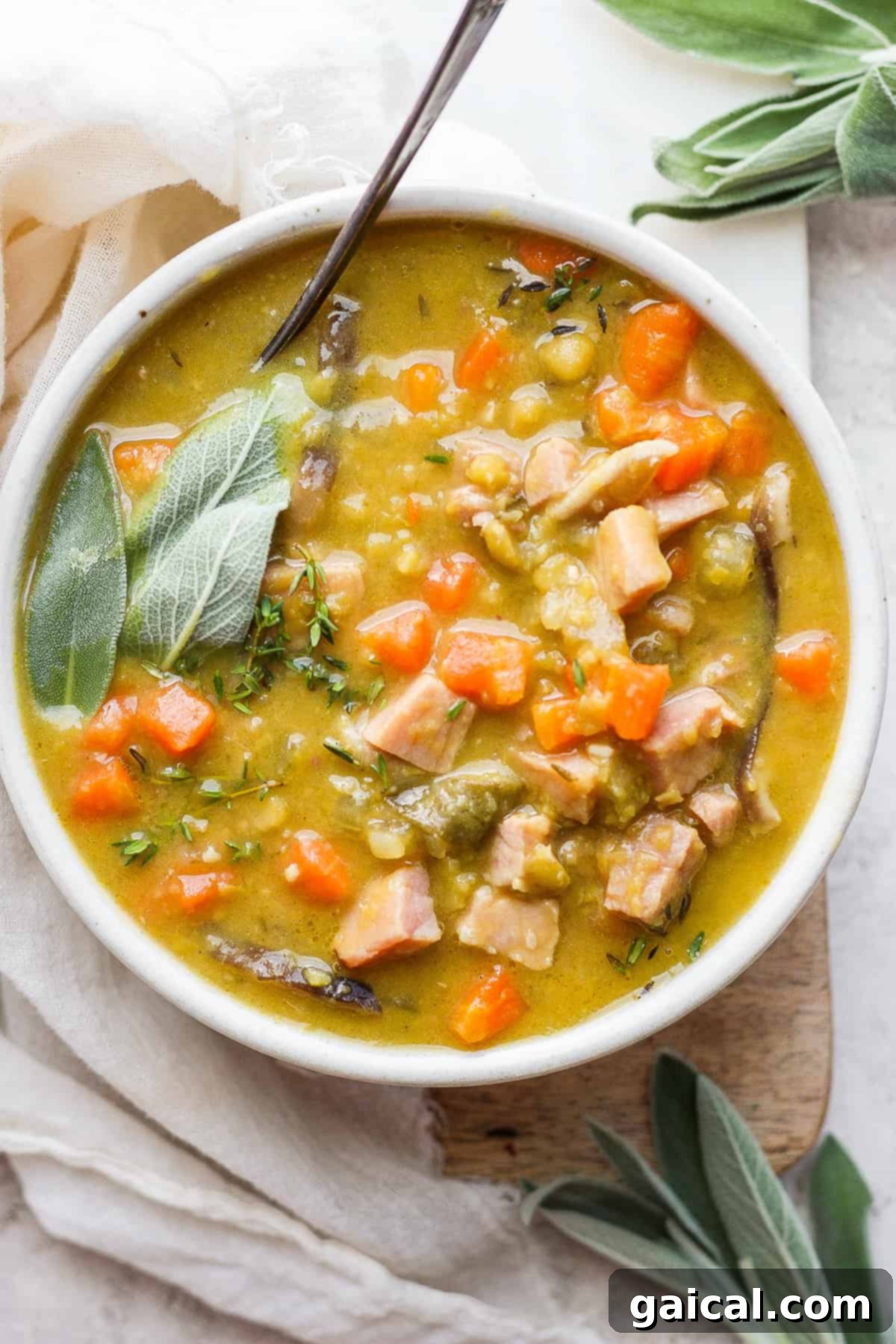 Hearty Ham and Split Pea Soup 2 Split pea soup with ham in a bowl with a spoon.