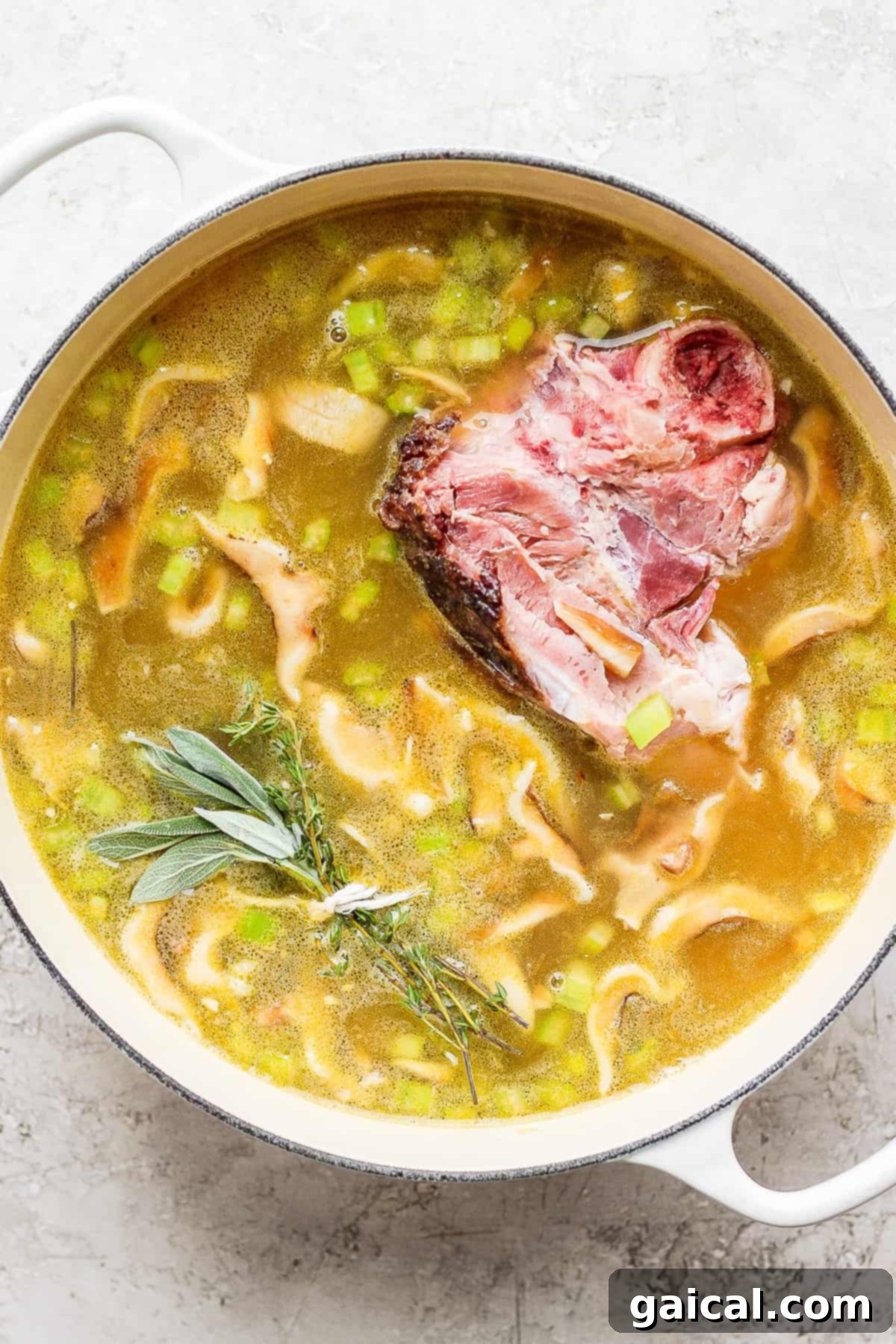Hearty Ham and Split Pea Soup 7 Split pea soup simmering in a dutch oven with a ham bone.