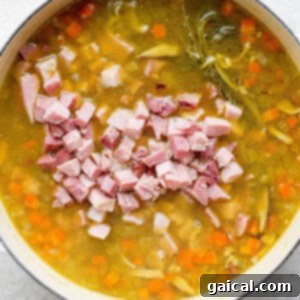 Hearty Ham and Split Pea Soup 14 A pot of soup with ham and carrots.