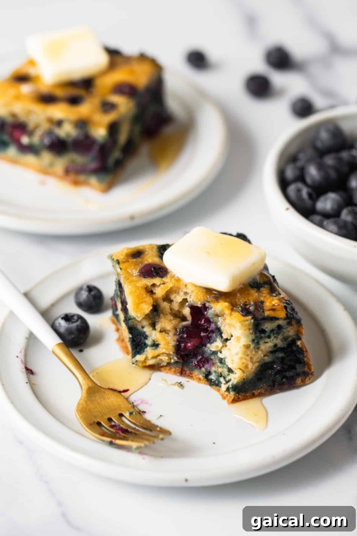 Golden Blueberry Coffee Cake 6 Individual slices of blueberry breakfast cake beautifully arranged on a white serving plate, ready to be enjoyed.