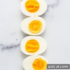 The Secret to Irresistible Egg Salad 5 Hard-boiled eggs chilling in an ice bath on a kitchen counter, prepared for peeling and further steps.