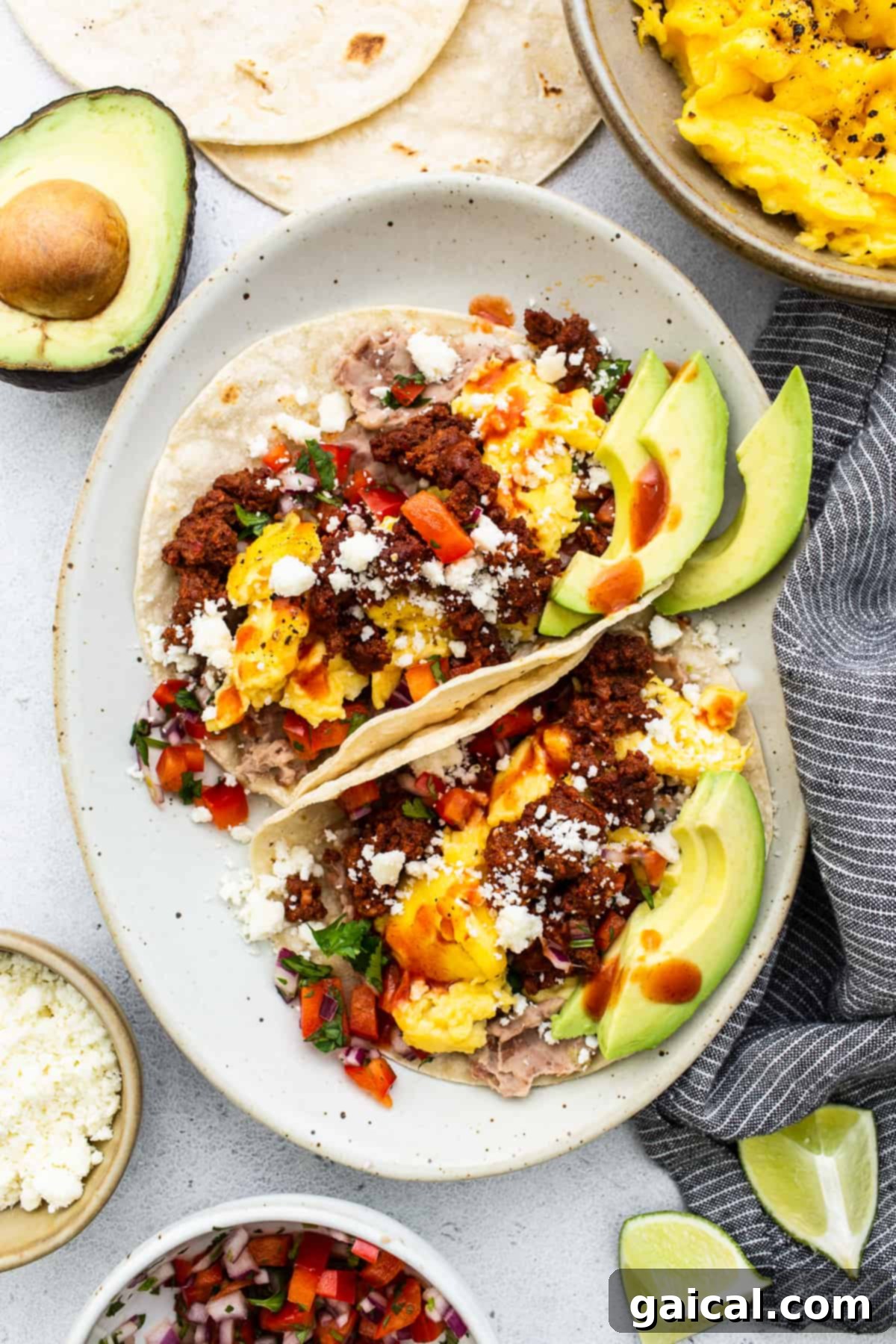 Delicious Breakfast Tacos Ready to Eat Two breakfast tacos generously filled with eggs, chorizo, beans, and fresh toppings, served on a plate ready to be enjoyed.