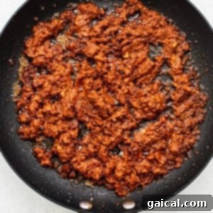 Morning Taco Delights 5 Ground chorizo cooking and browning in a skillet.