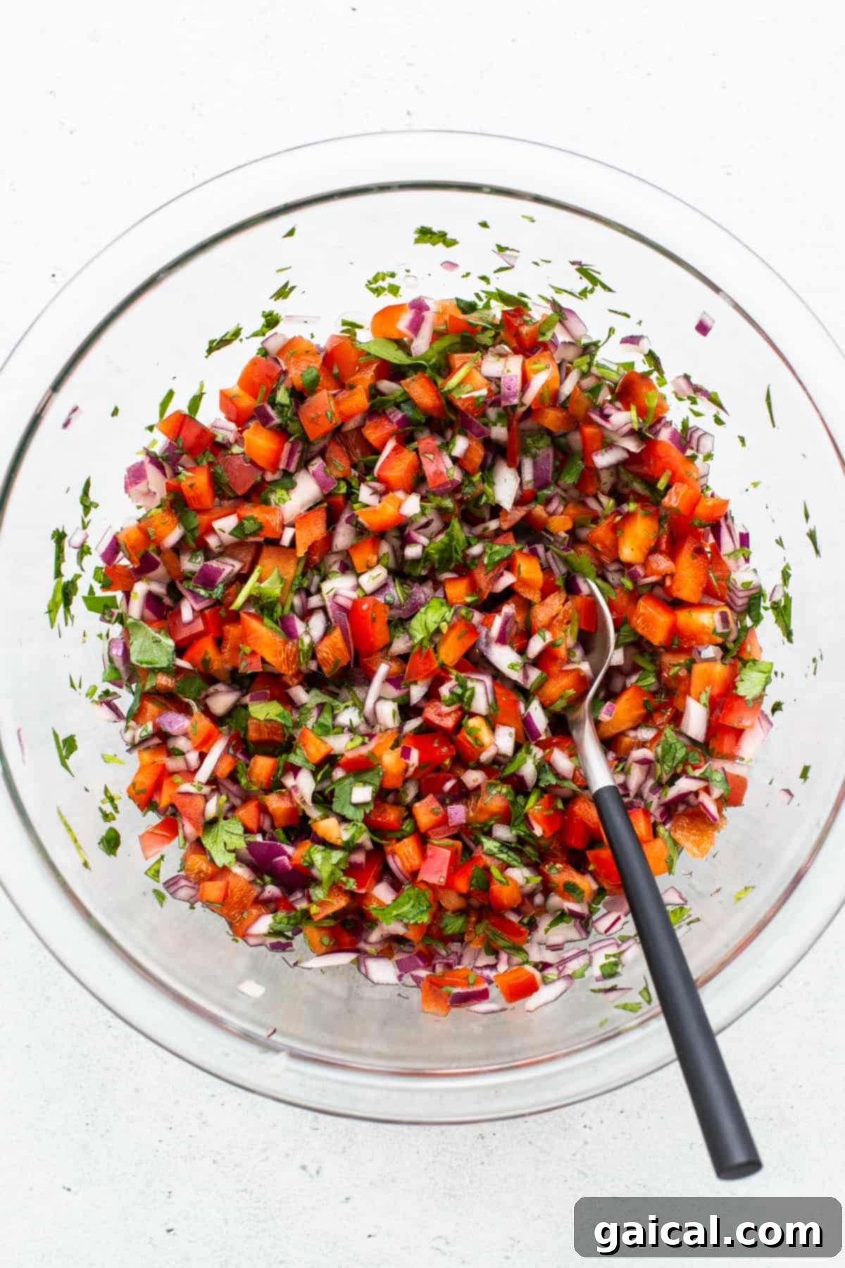 Fresh Pico de Gallo for Tacos Freshly made pico de gallo in a glass bowl, featuring diced tomatoes, onions, cilantro, and jalapeños.