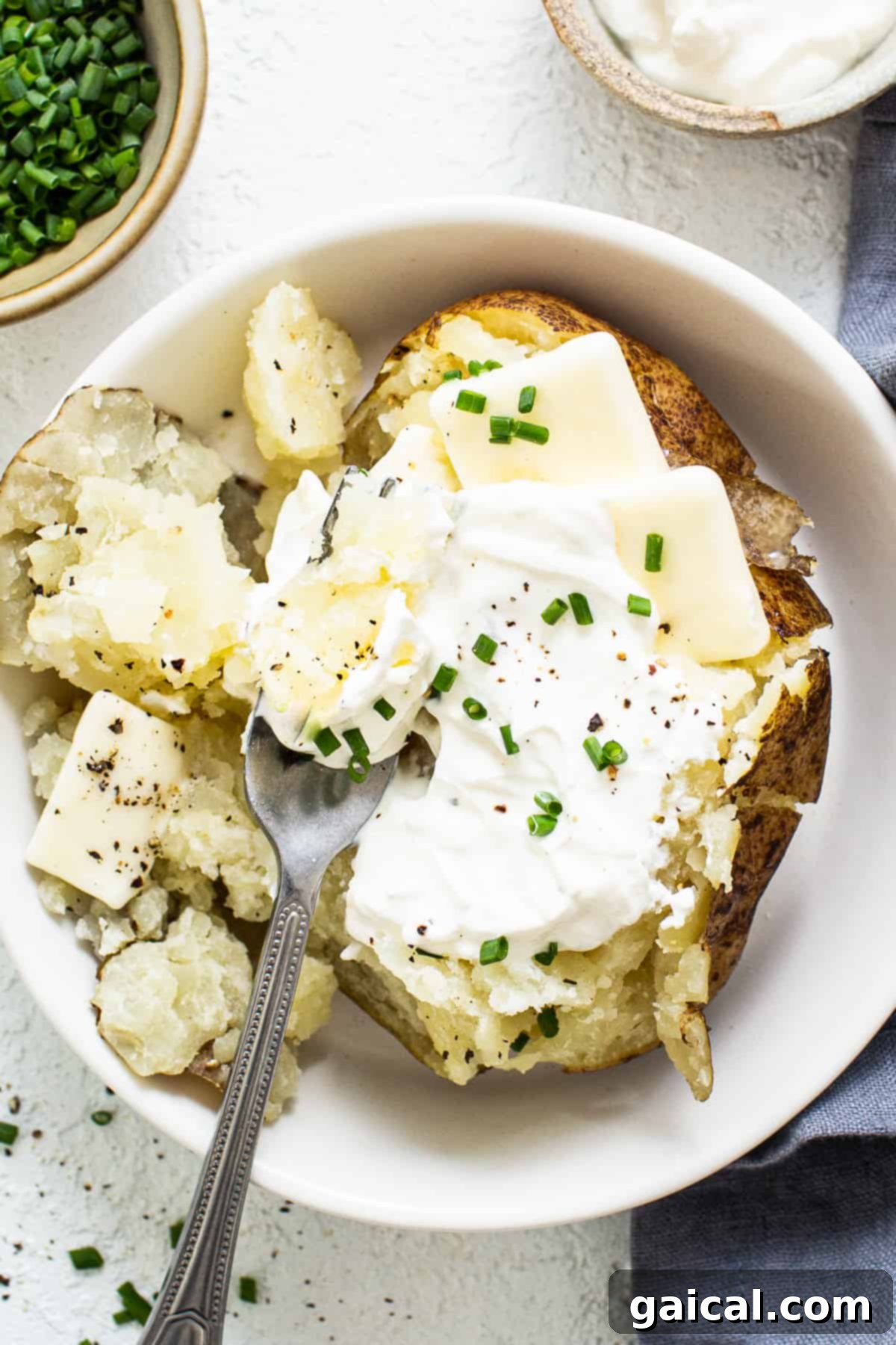 A perfectly baked potato served in a bowl, ready to be topped.