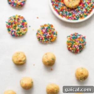 Masa cookies covered in sprinkles on a parchment-lined plate, ready for chilling.
