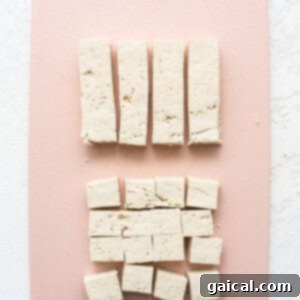 Tofu cubes on a pink cutting board.