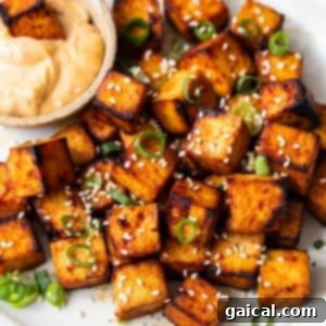 Crispy air fryer tofu served on a plate with a flavorful dipping sauce, showcasing a healthy and easy alternative.