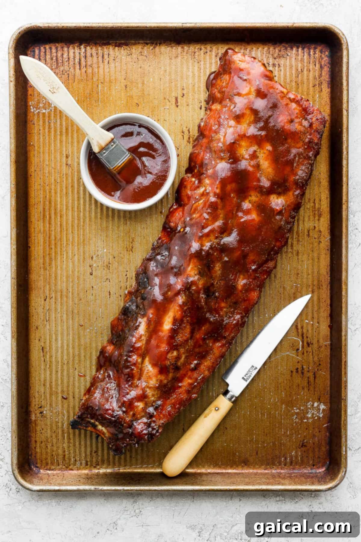 Grilled ribs resting on a baking sheet, ready for serving or slicing.