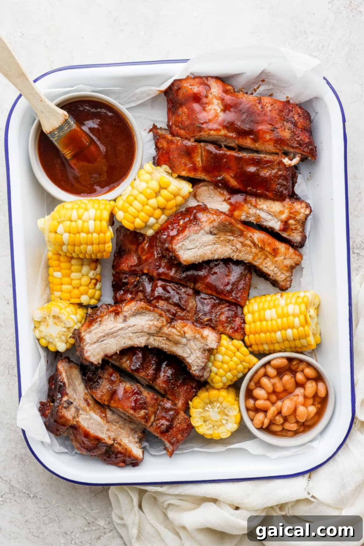 Beautifully grilled ribs arranged on a serving tray, drizzled with BBQ sauce.