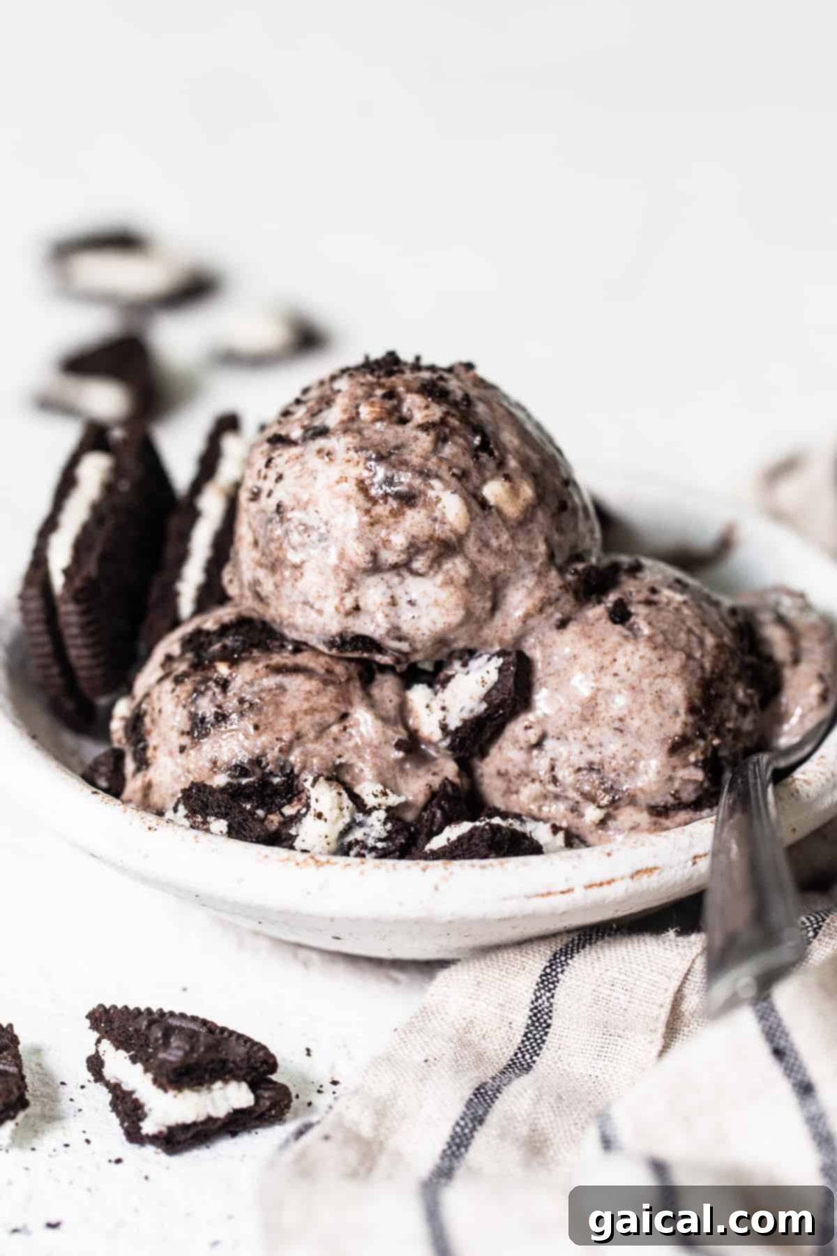 Cookies & Cream Protein Dream 2 A beautifully presented bowl of creamy cookies and cream cottage cheese ice cream with three scoops, topped with extra crushed Oreo pieces, showcasing its rich texture.
