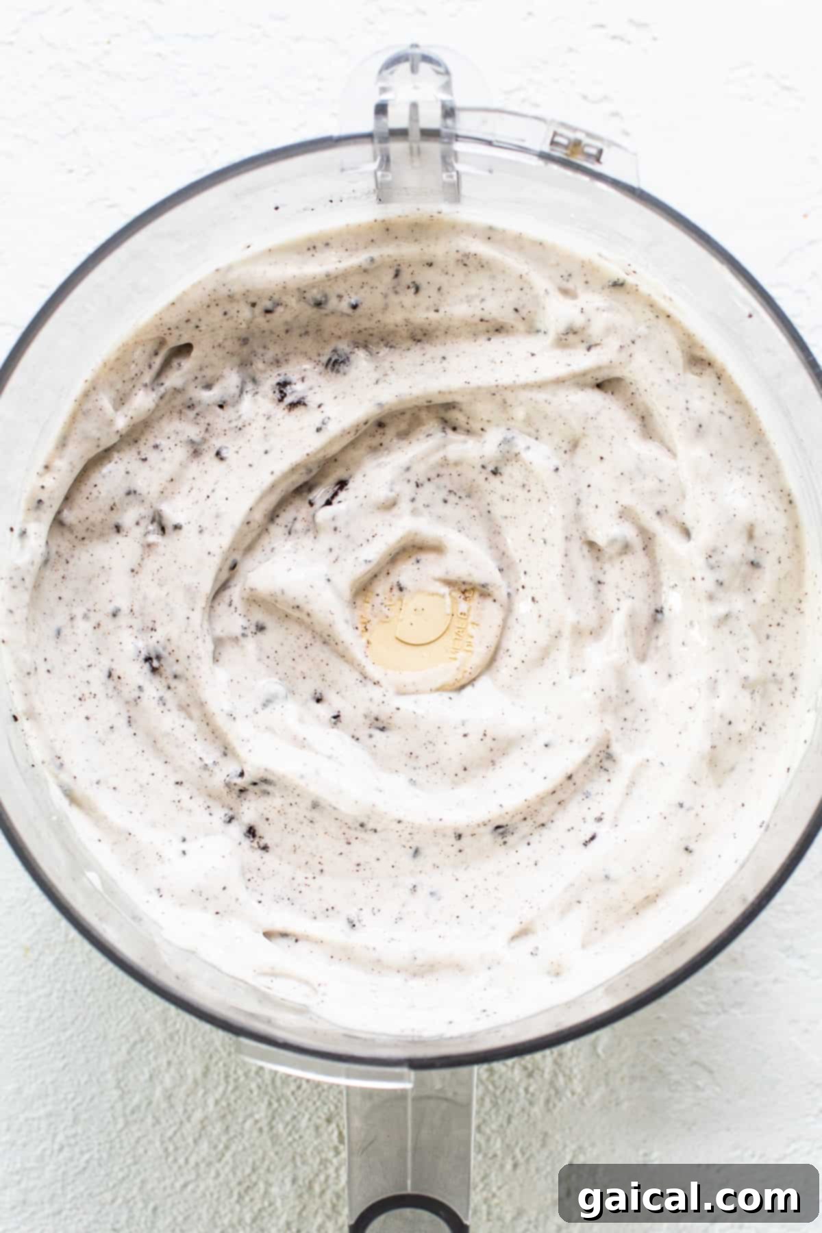 Cookies & Cream Protein Dream 5 The smooth, blended cottage cheese ice cream mixture with Oreo chunks inside a food processor bowl, ready for freezing.