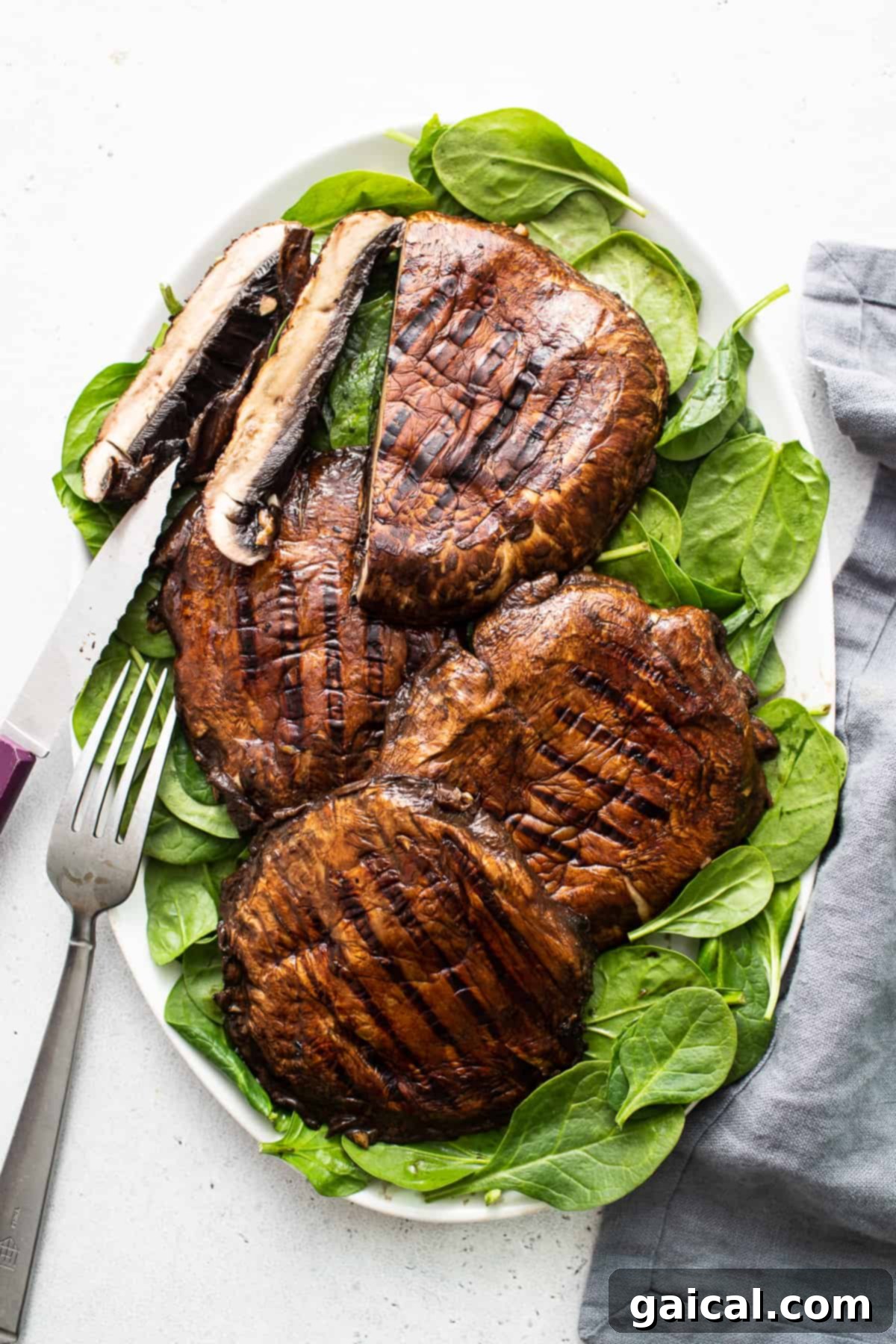 Smoky Grilled Portobello Steaks 2 Perfectly grilled portobello mushrooms served on a plate, garnished with fresh herbs.