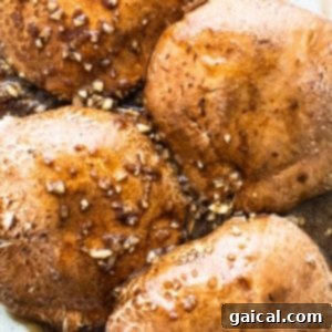 Smoky Grilled Portobello Steaks 11 Marinating portobello mushrooms in a baking dish, thoroughly coated in sauce.