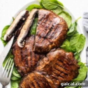 Smoky Grilled Portobello Steaks 13 Grilled mushrooms and spinach on a plate, presenting a healthy and delicious meal.