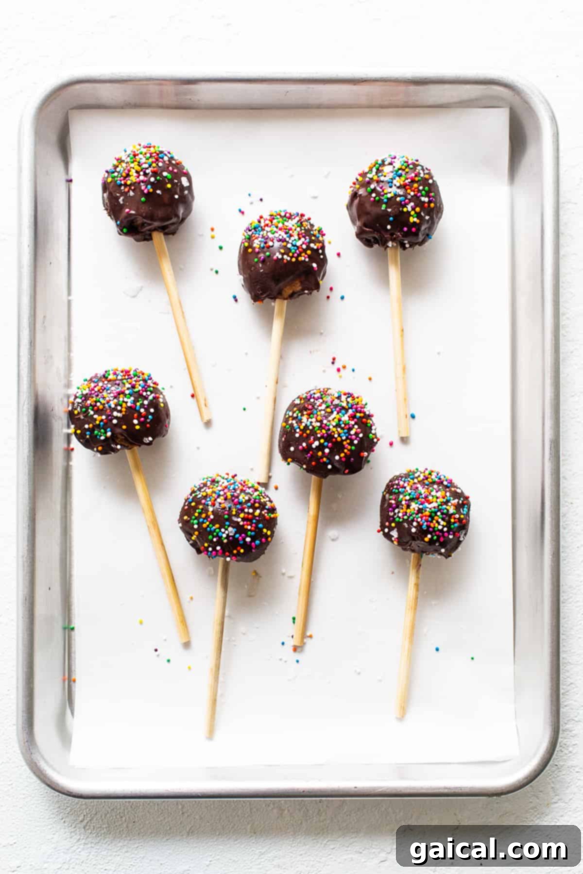 Protein-Packed Cake Pops 7 A vibrant display of finished protein cake pops resting on a cookie sheet.