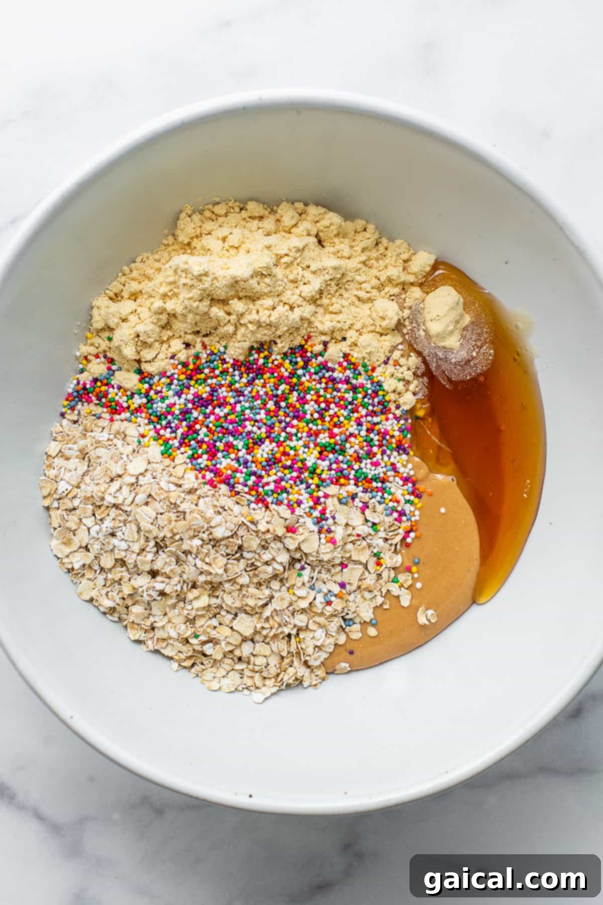 Protein-Packed Cake Pops 4 Key ingredients for protein cake pops artfully displayed in a single mixing bowl.