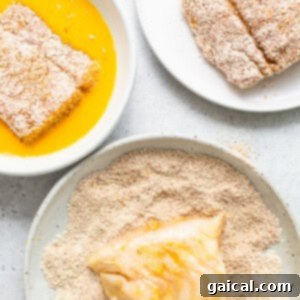 Golden Crunchy Air Fryer Fish Fillets 5 A fish filet being coated in a breadcrumb mixture.