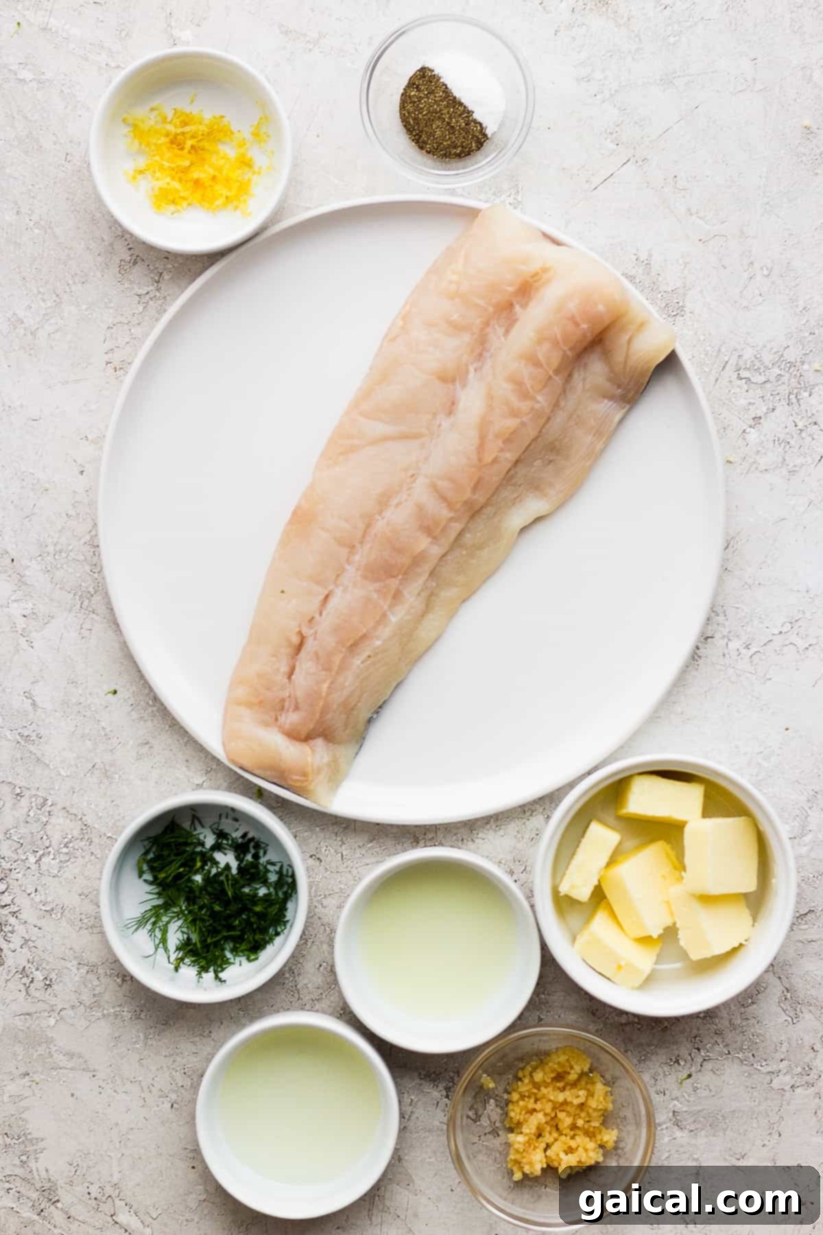 Fresh Ingredients for Your Grilled Fish Masterpiece A beautiful flat lay photograph showcasing all the fresh ingredients for the grilled fish recipe, including lemon halves, fresh dill, garlic cloves, olive oil, butter, salt, pepper, and raw fish fillets arranged on a plate.