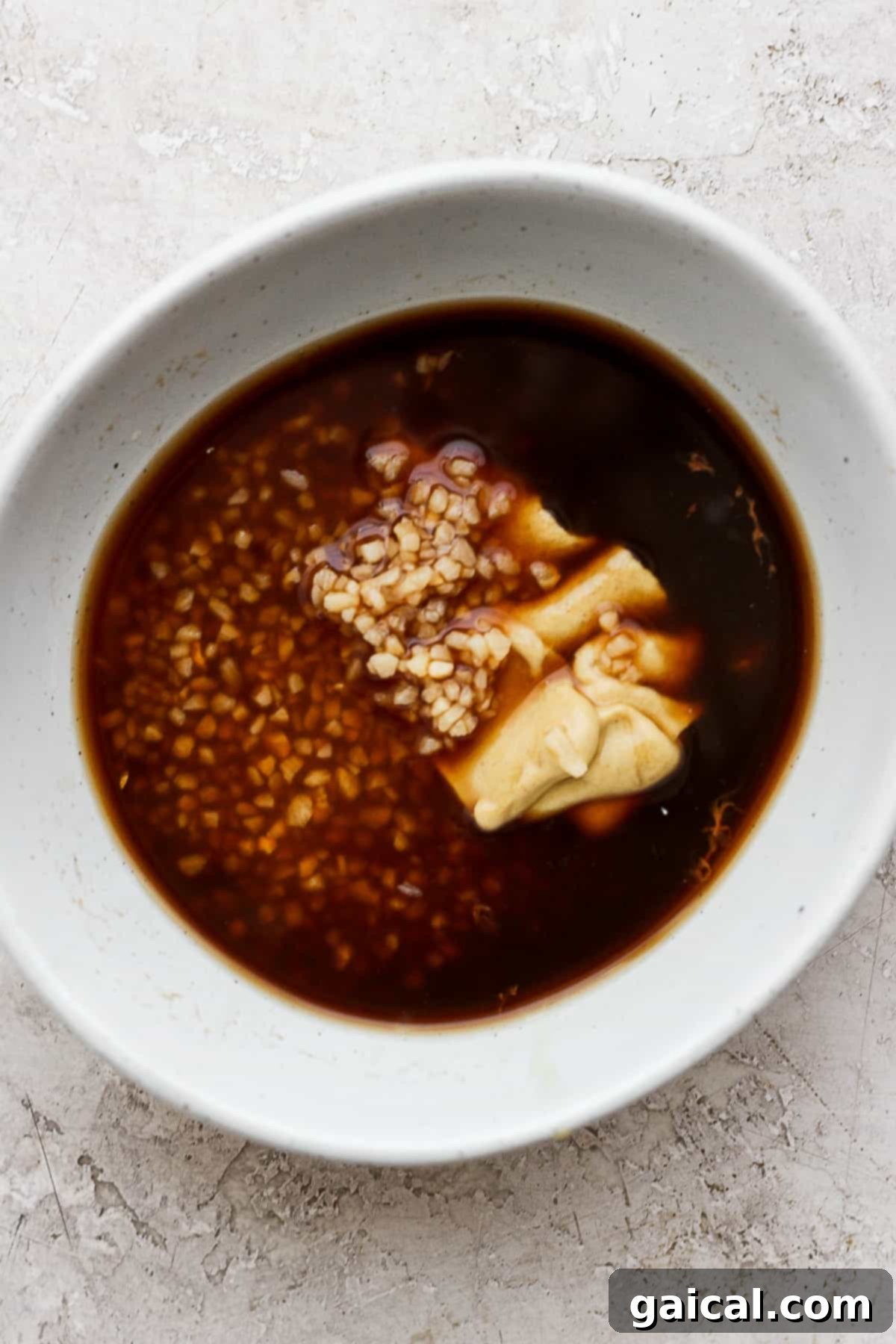 This classic rib marinade recipe is perfectly savory and sweet with only 5 ingredients -- an amazing complement to your baby back ribs. Enjoy! Rib marinade ingredients in a bowl.