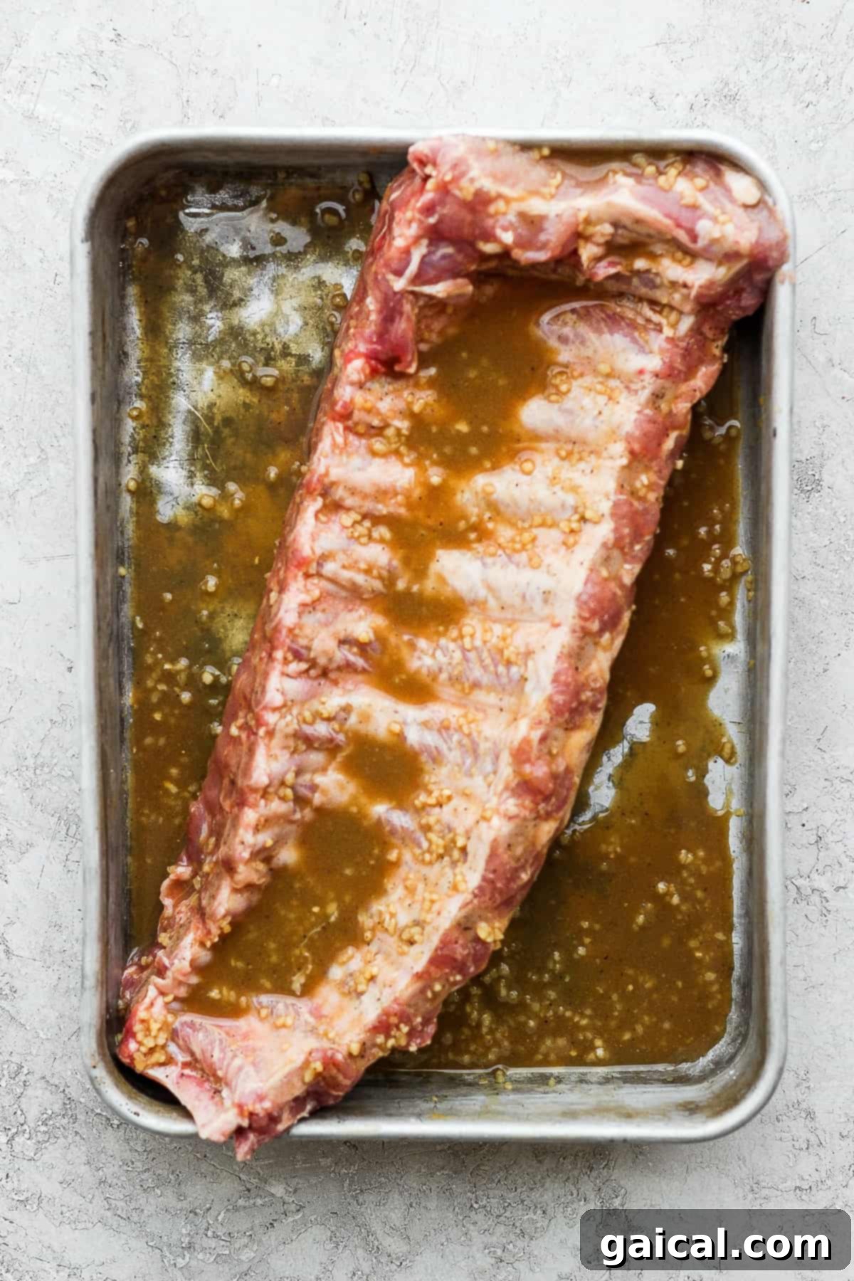 This classic rib marinade recipe is perfectly savory and sweet with only 5 ingredients -- an amazing complement to your baby back ribs. Enjoy! Rack of baby back ribs in a rib marinade.