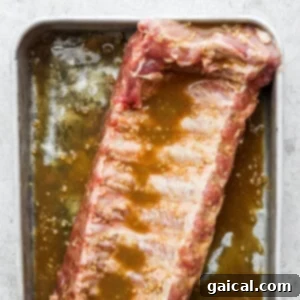 a piece of meat sitting on top of a pan covered in sauce.