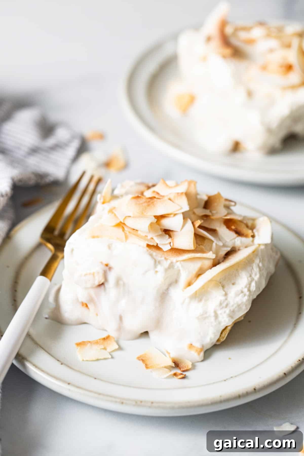 Creamy Coconut Dream Bars 2 A perfectly sliced piece of coconut cream pie bar on a white plate, showcasing its creamy layers and toasted coconut topping.