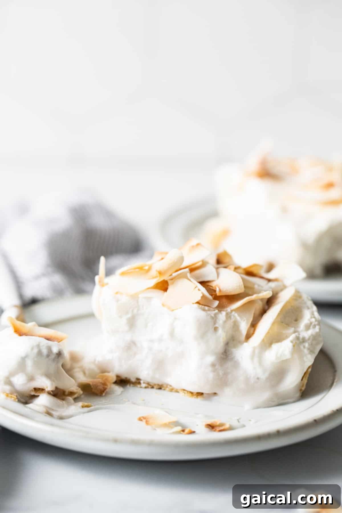 Creamy Coconut Dream Bars 8 A full-size coconut cream pie bar, meticulously crafted and ready to be served, placed on a serving dish.