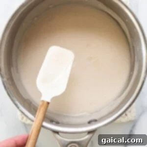 a person holding a spatula in a saucepan.