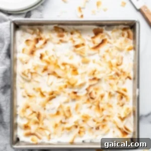 a pan filled with a dessert covered in coconut flakes.