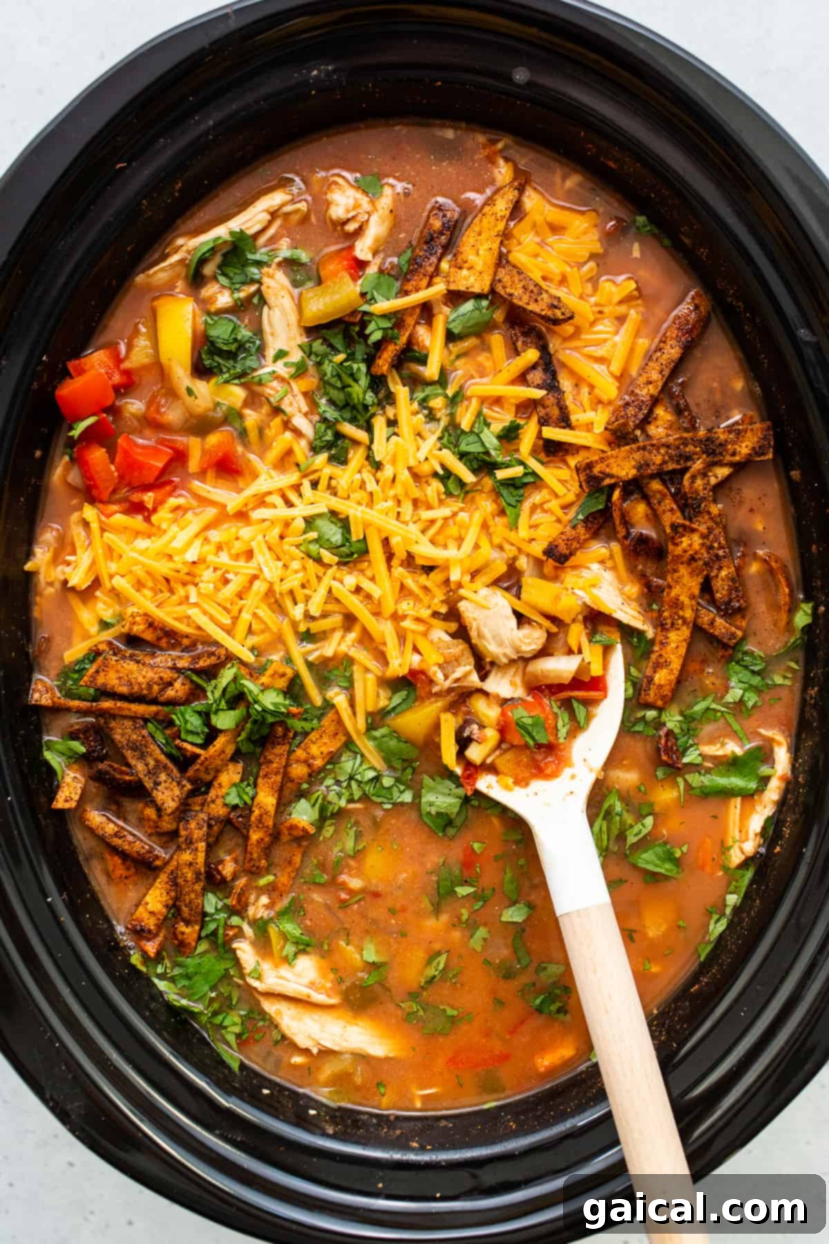 Hearty Chicken Tortilla Soup in Slow Cooker A slow cooker filled with ready-to-serve chicken tortilla soup, garnished and steaming.