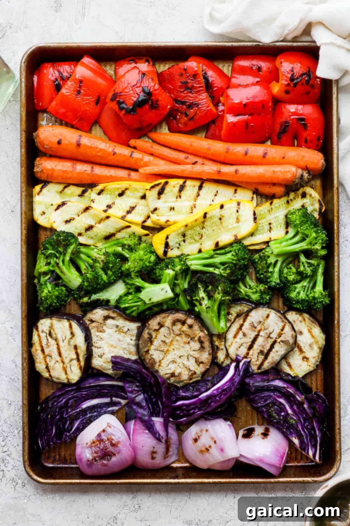 A colorful tray of perfectly grilled vegetables, including vibrant carrots, crisp broccoli florets, and tender red onions, ready to be served.