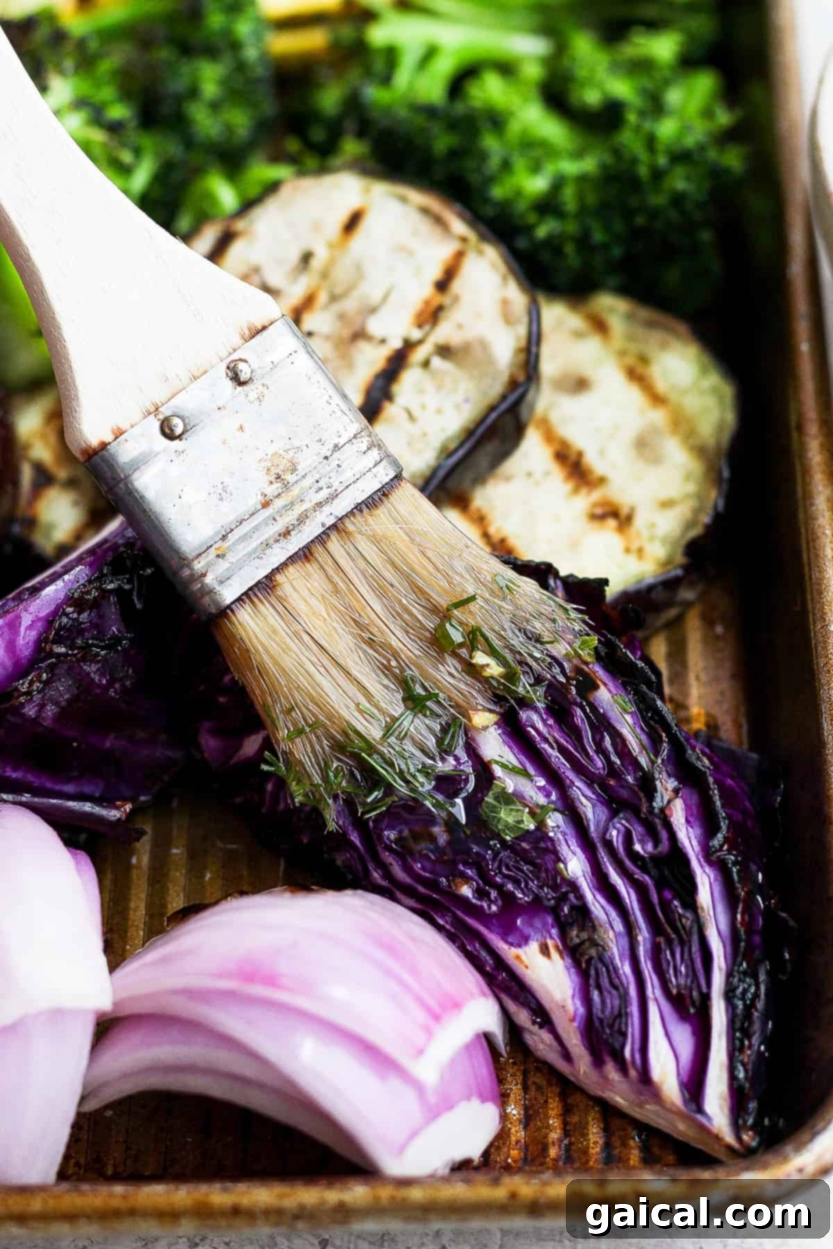 A close-up of a pastry brush coated with the vibrant herby marinade, ready to baste the grilled vegetables.