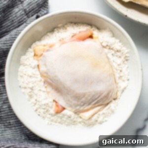 Dynamite Chicken Thighs 5 a white bowl filled with flour next to a chicken breast.