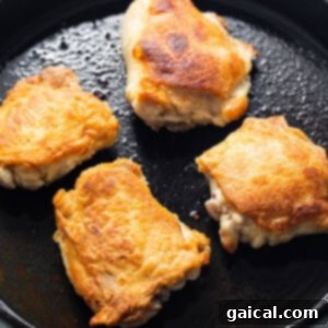 Dynamite Chicken Thighs 6 four pieces of food cooking in a skillet.