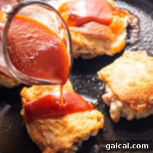 Dynamite Chicken Thighs 7 a person pouring ketchup on some food in a skillet.