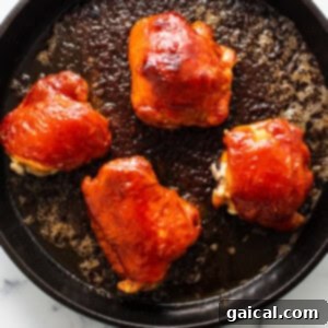 Dynamite Chicken Thighs 8 four pieces of chicken in a skillet on a marble counter top.