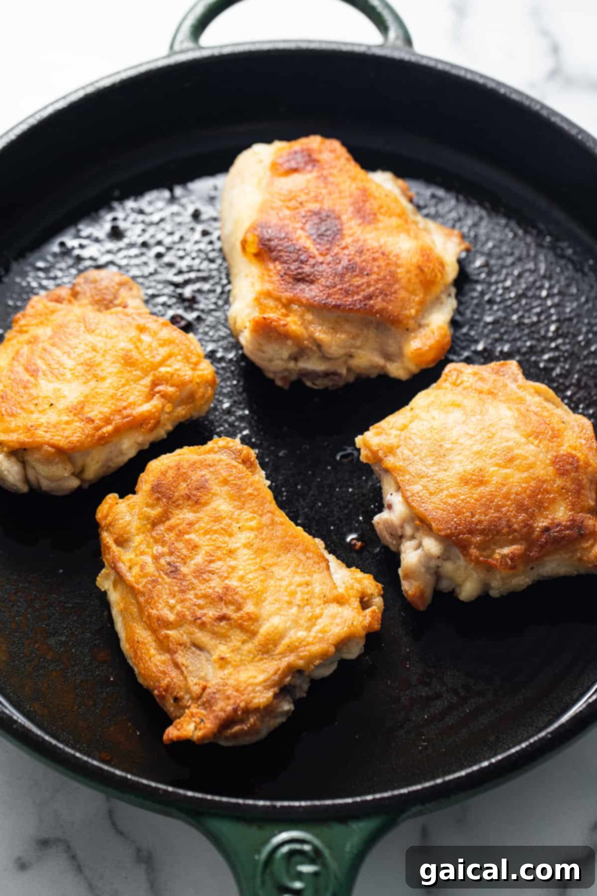 Dynamite Chicken Thighs 10 chicken thighs searing in a skillet.