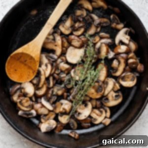 mushrooms in a skillet with a wooden spoon.