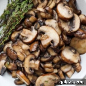 mushrooms in a white bowl with a sprig of thyme.
