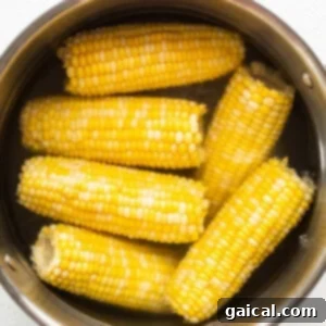 Sunshine Corn Salsa 6 Cooked corn on the cob being removed from a pot.