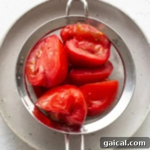 Sunshine Corn Salsa 9 Ripe tomatoes resting in a metal strainer with salt.