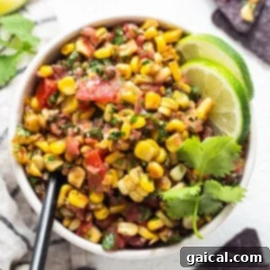 Sunshine Corn Salsa 12 A bowl of fresh corn salsa garnished with limes and tortilla chips.