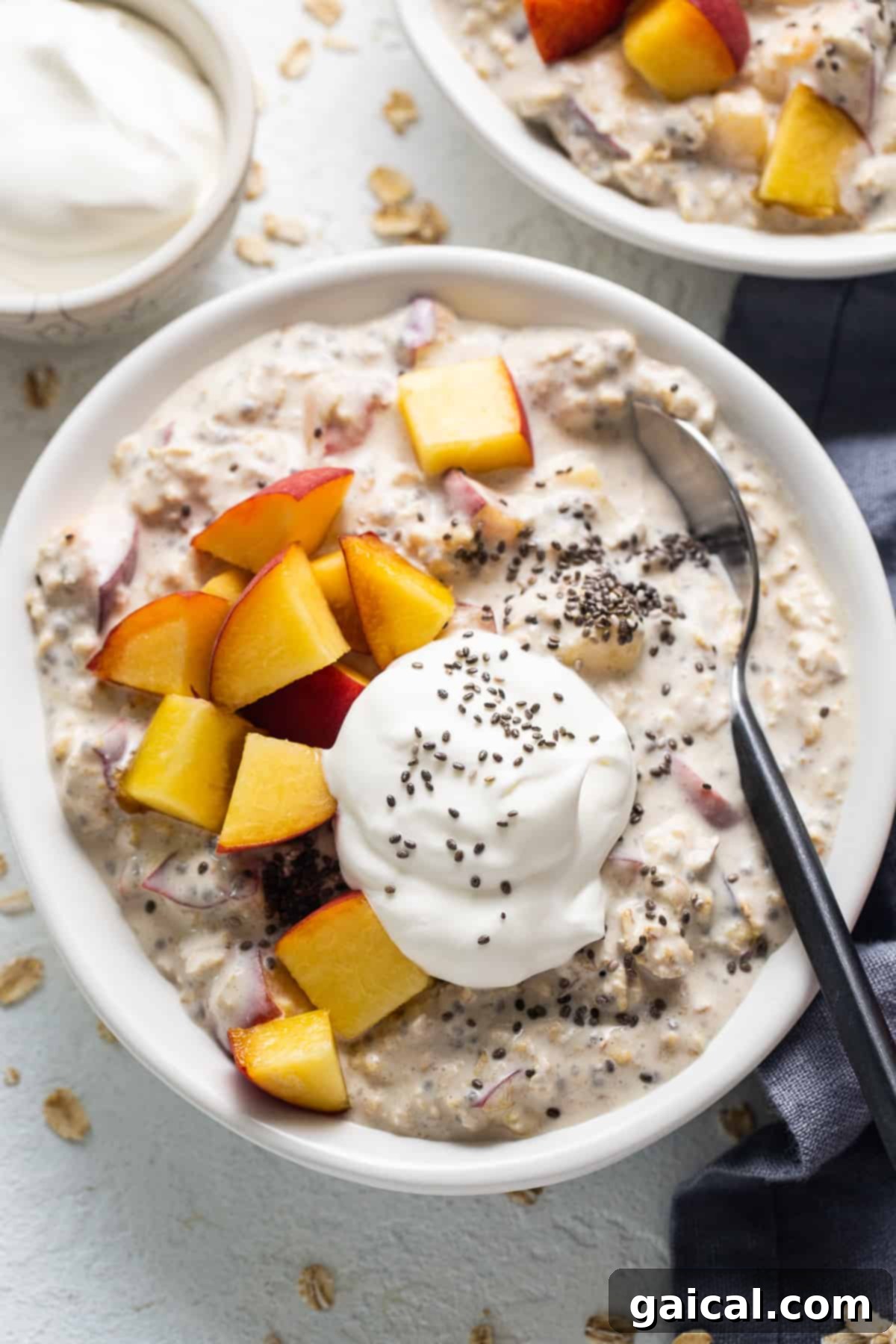 Golden Peach Overnight Bliss 2 A beautifully layered jar of peaches and cream overnight oats, garnished with fresh peach slices and a dollop of cream.