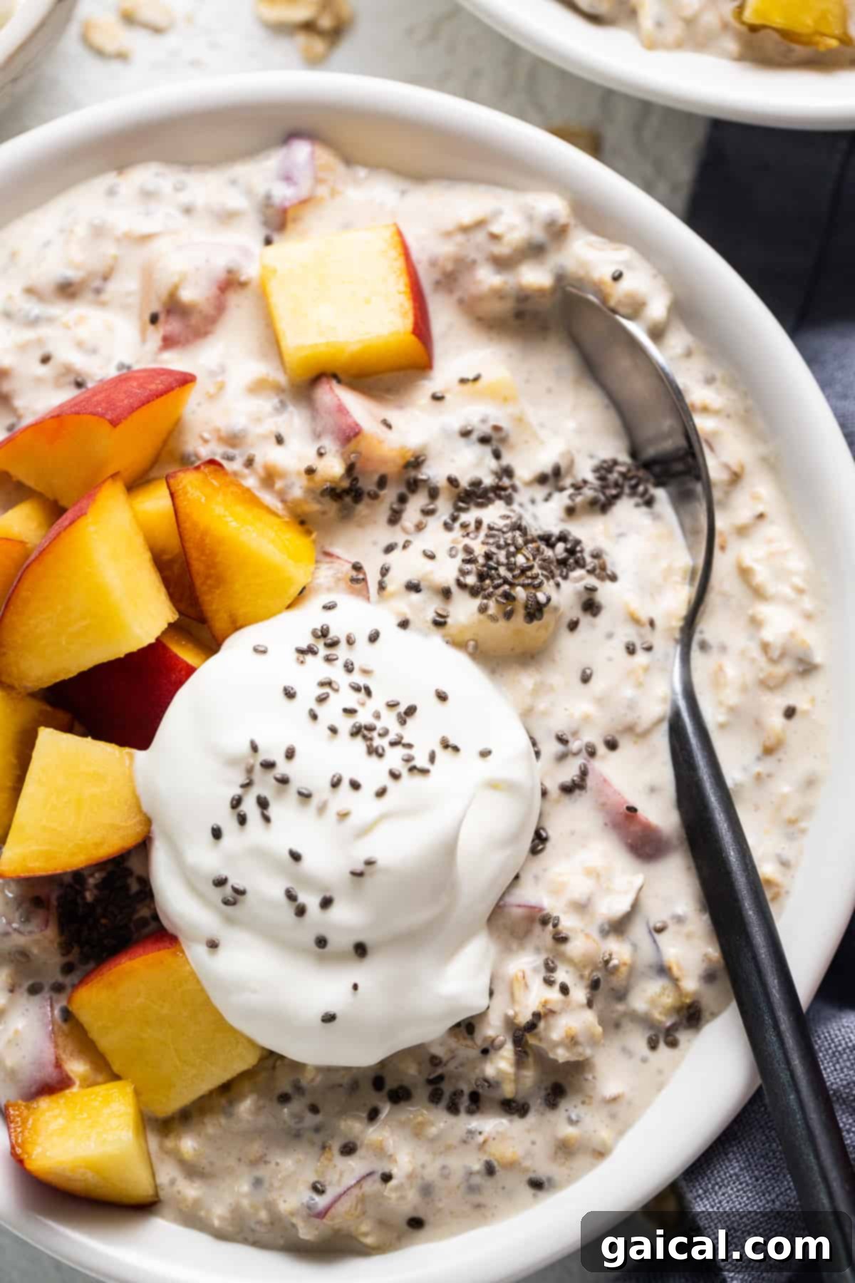 Golden Peach Overnight Bliss 6 A spoon scooping creamy peach overnight oats from a glass jar, demonstrating its perfect consistency.